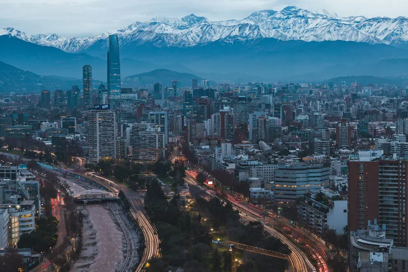 Panorámica urbana de Santiago con el rascacielos Costanera Center y la cordillera de los Andes nevada de fondo.